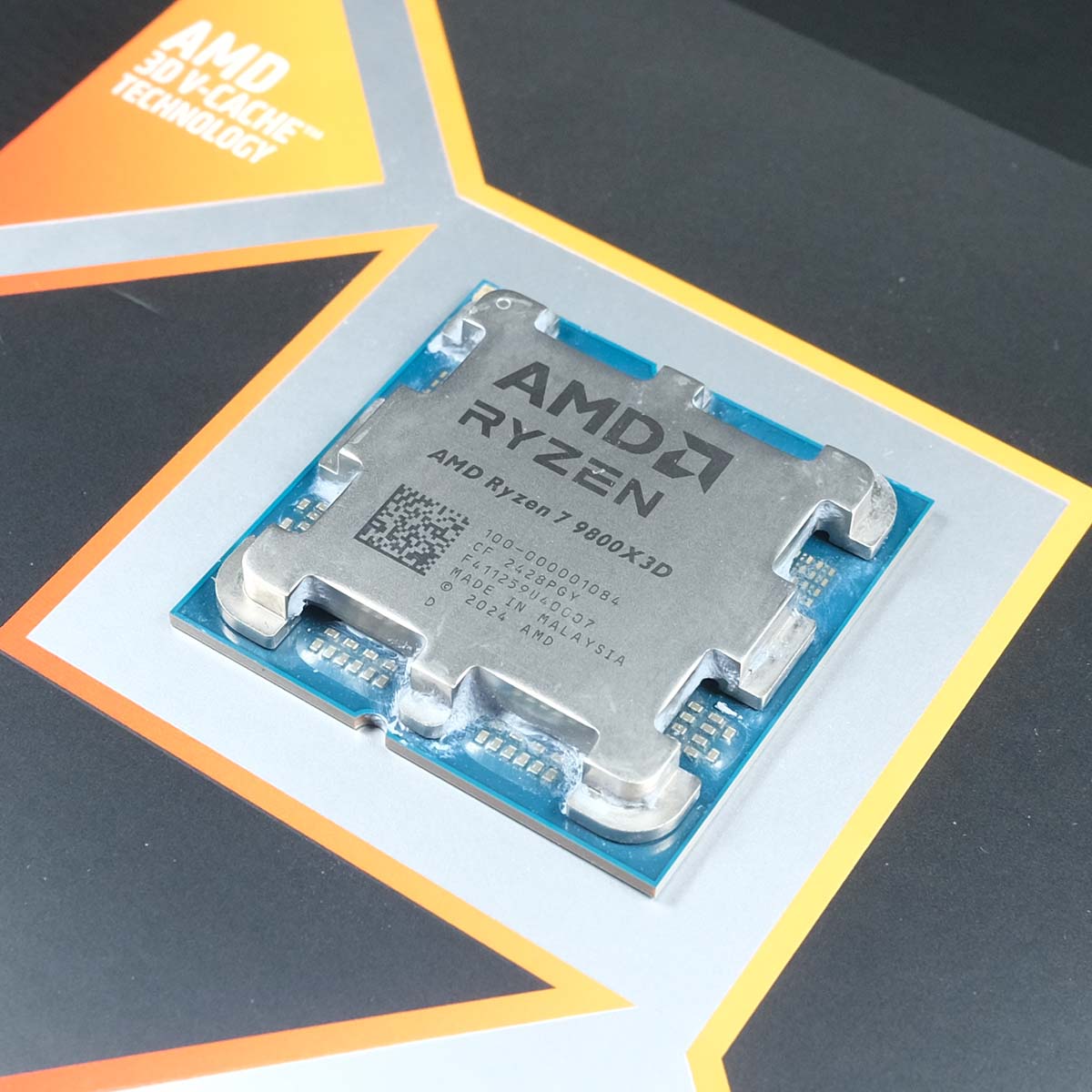 An AMD Ryzen 7 9800X3D sitting on top of its retail packaging.