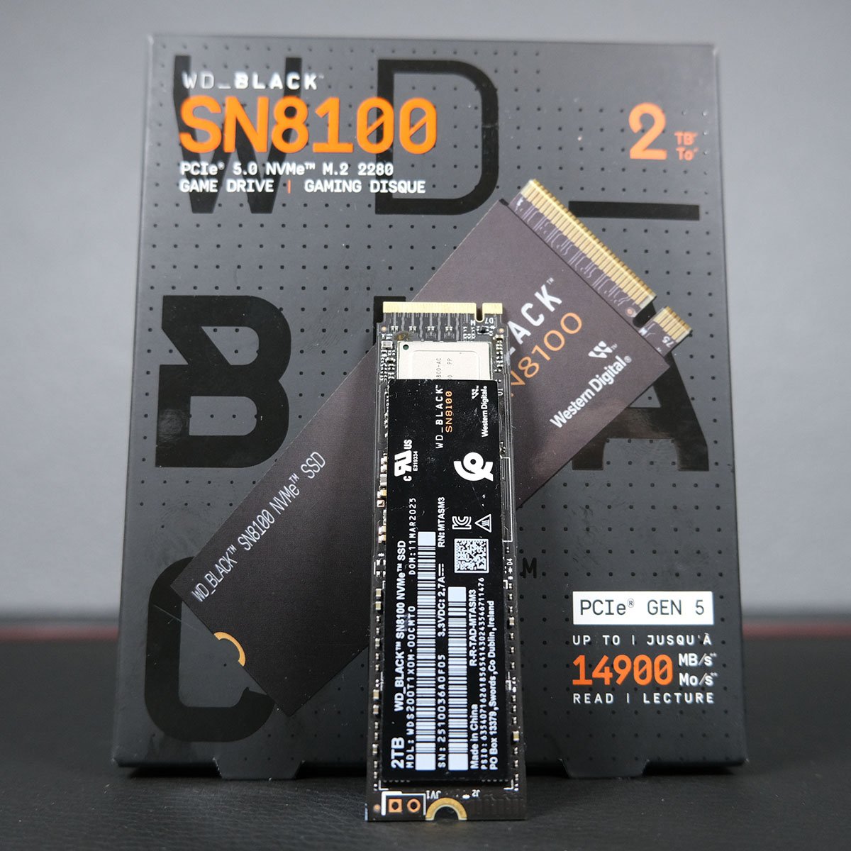 A 2TB WD_Black SN8100 SSD standing upright, against its packaging.