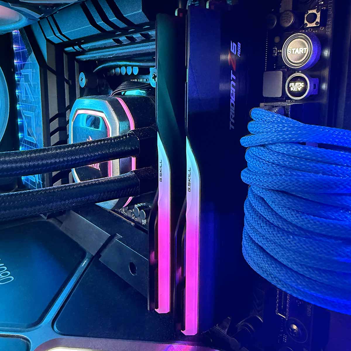 A picture of G.Skill Trident Z RGB 7,200MT/s installed in a PC with RGB lighting shining through.