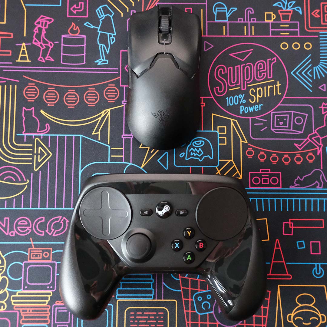 A gaming mouse (top) and a Steam Controller (bottom), lying on a desk pad.