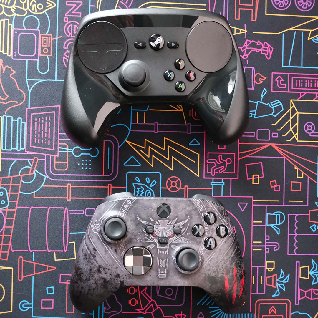 A Steam Controller (top) and Xbox Series controller (bottom) lying flat atop a desk mat.