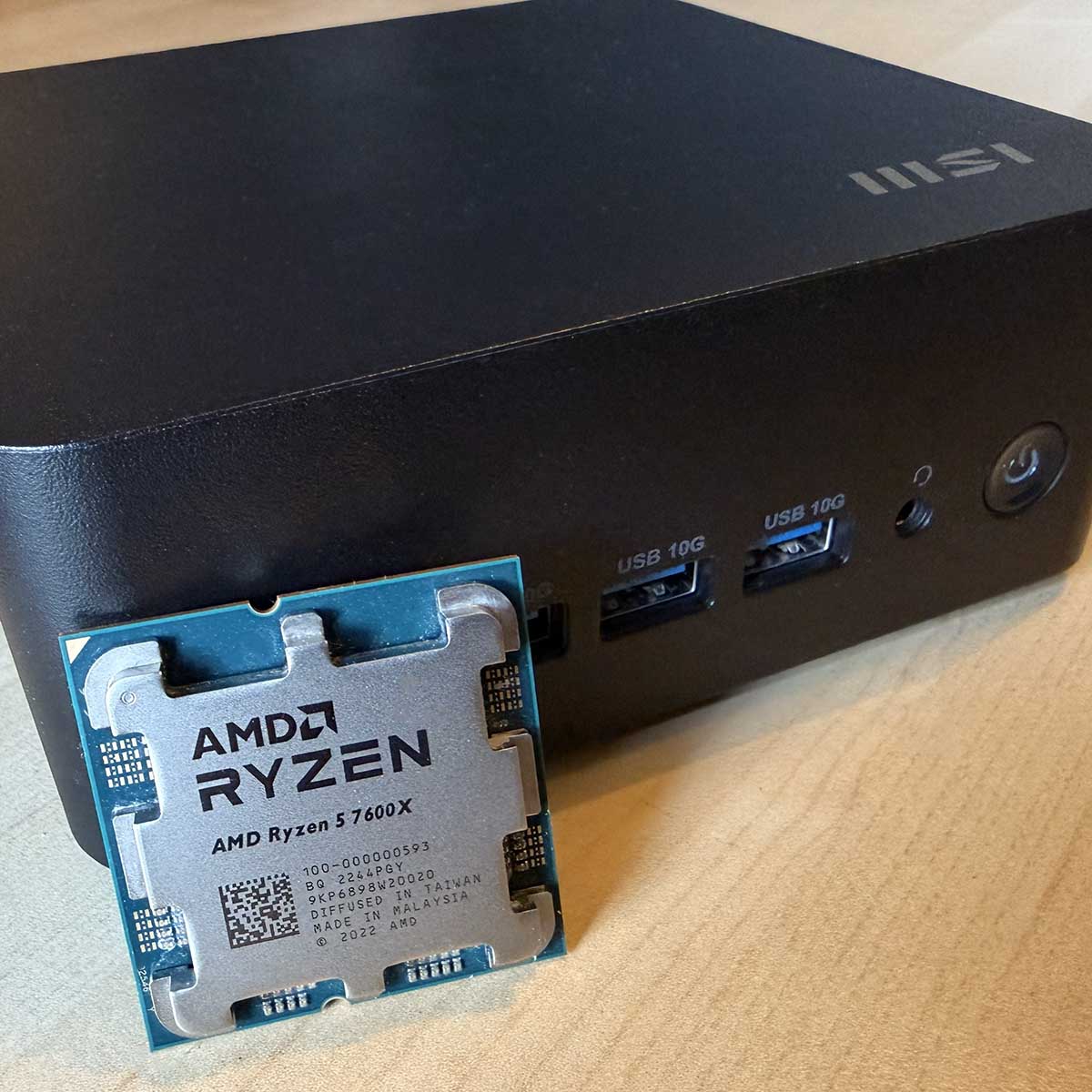 MSI Cubi vs desktop: Mini PC next to AMD Ryzen 5 7600X CPU