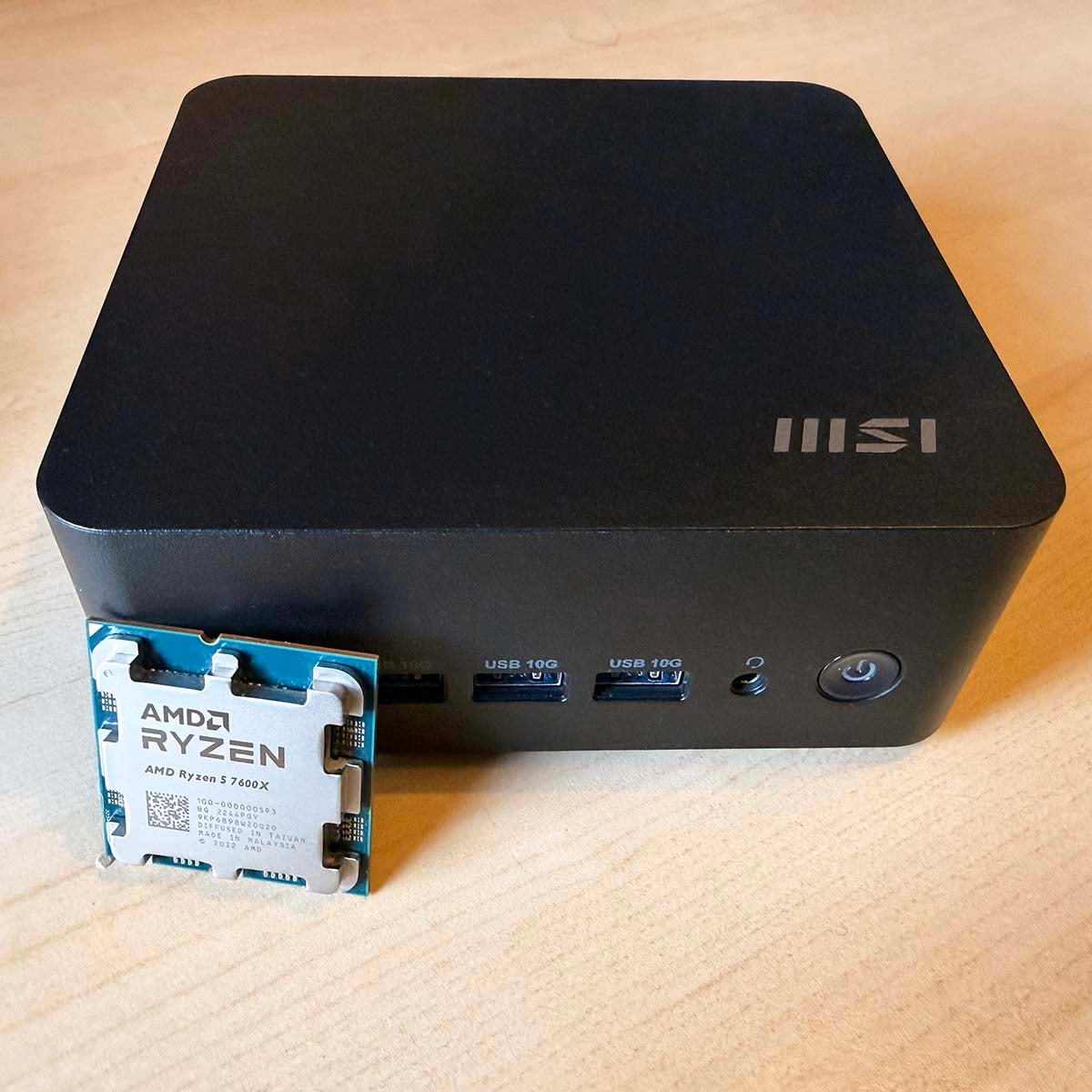 MSI Cubi vs desktop: Mini PC next to AMD Ryzen 5 7600X CPU