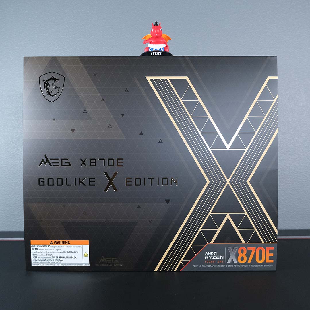 MSI MEG X870E Godlike X Edition packaging, complete with cardboard wrap, with a plastic Lucky the Dragon figurine sitting atop.