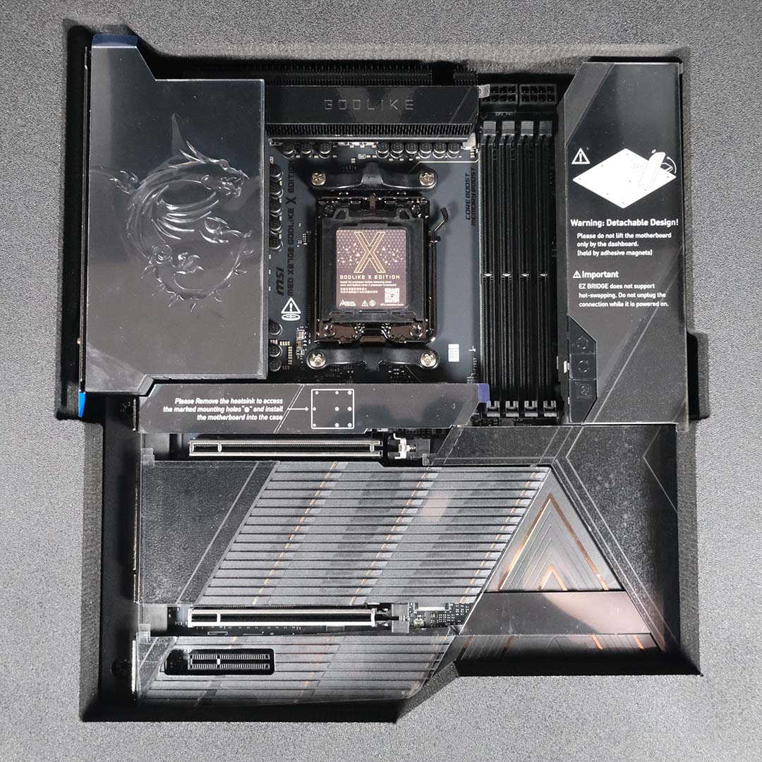 A top-down view of the MSI MEG X870E Godlike X surrounded by a foam insert inside its retail packaging.