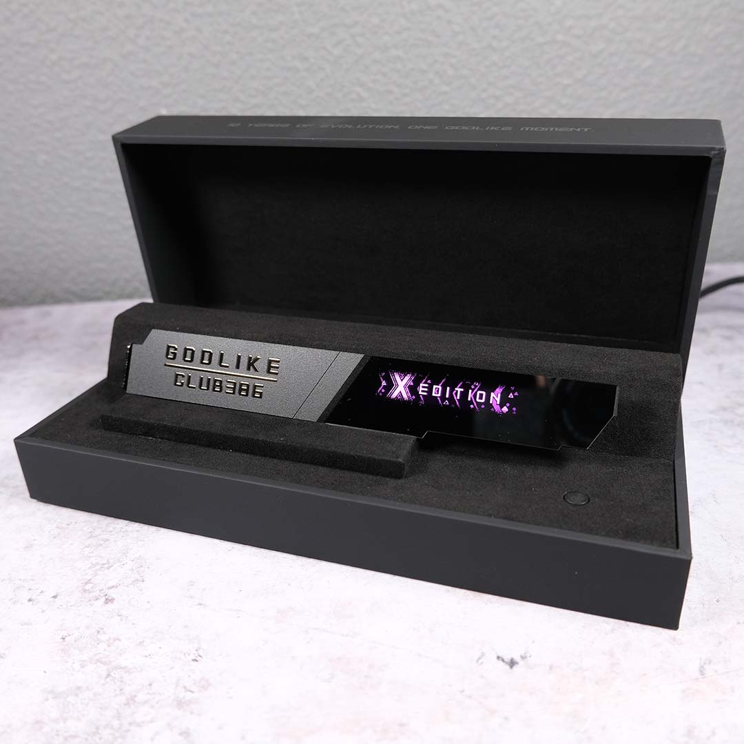 A wide shot of the custom 'Godlike - Club386' M.2 heatsink that came inside our MSI MEG X870E Godlike X review sample, sitting inside a display case.