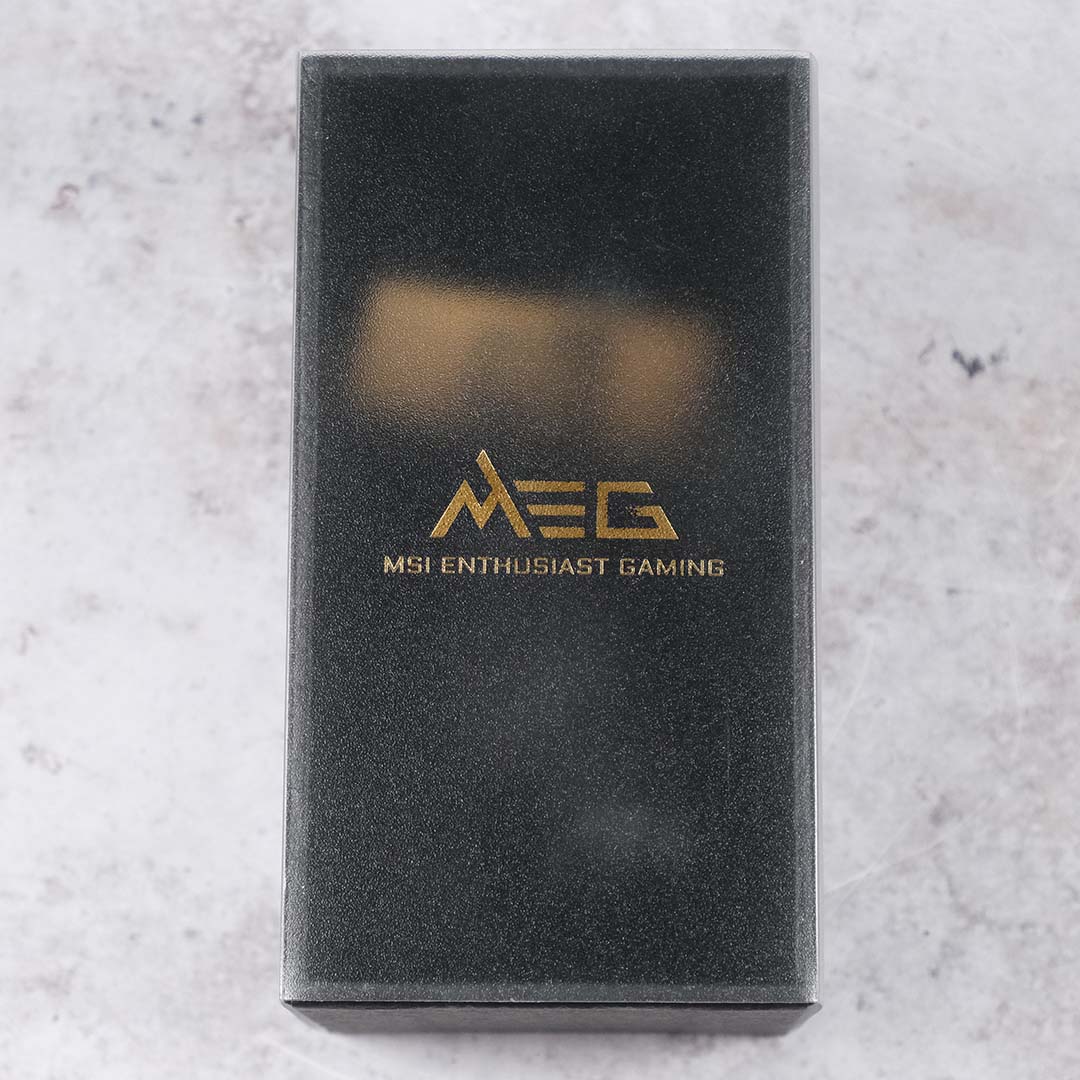 A top-down view of the packaging containing a Lucky the Dragon plush and several key rings.