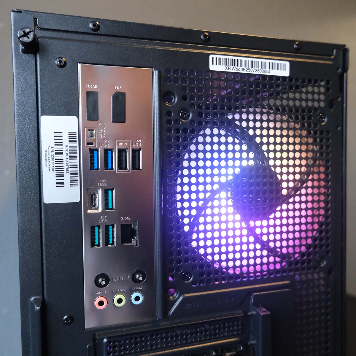 A close-up of the rear I/O (left) and exhaust fan (right) on the PCSpecialist Aegis Pro R gaming PC.