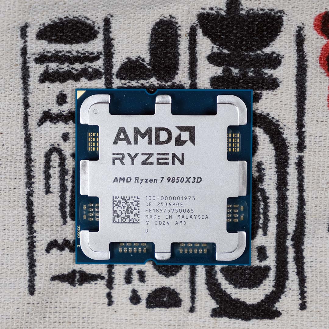 An AMD Ryzen 7 9850X3D processor, atop some hieroglyphs.