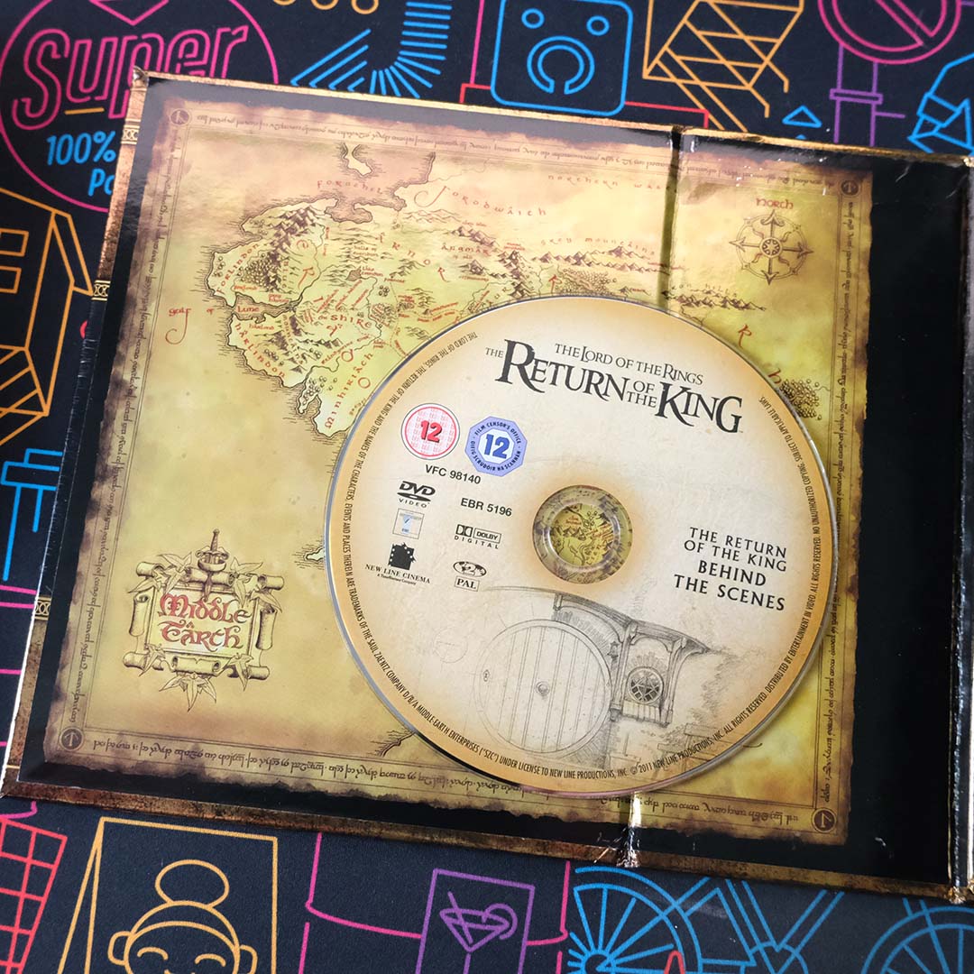 A Blu-ray disc for The Lord of the Rings: The Return of the King's Behind the Scenes, atop a map of Middle-Earth.