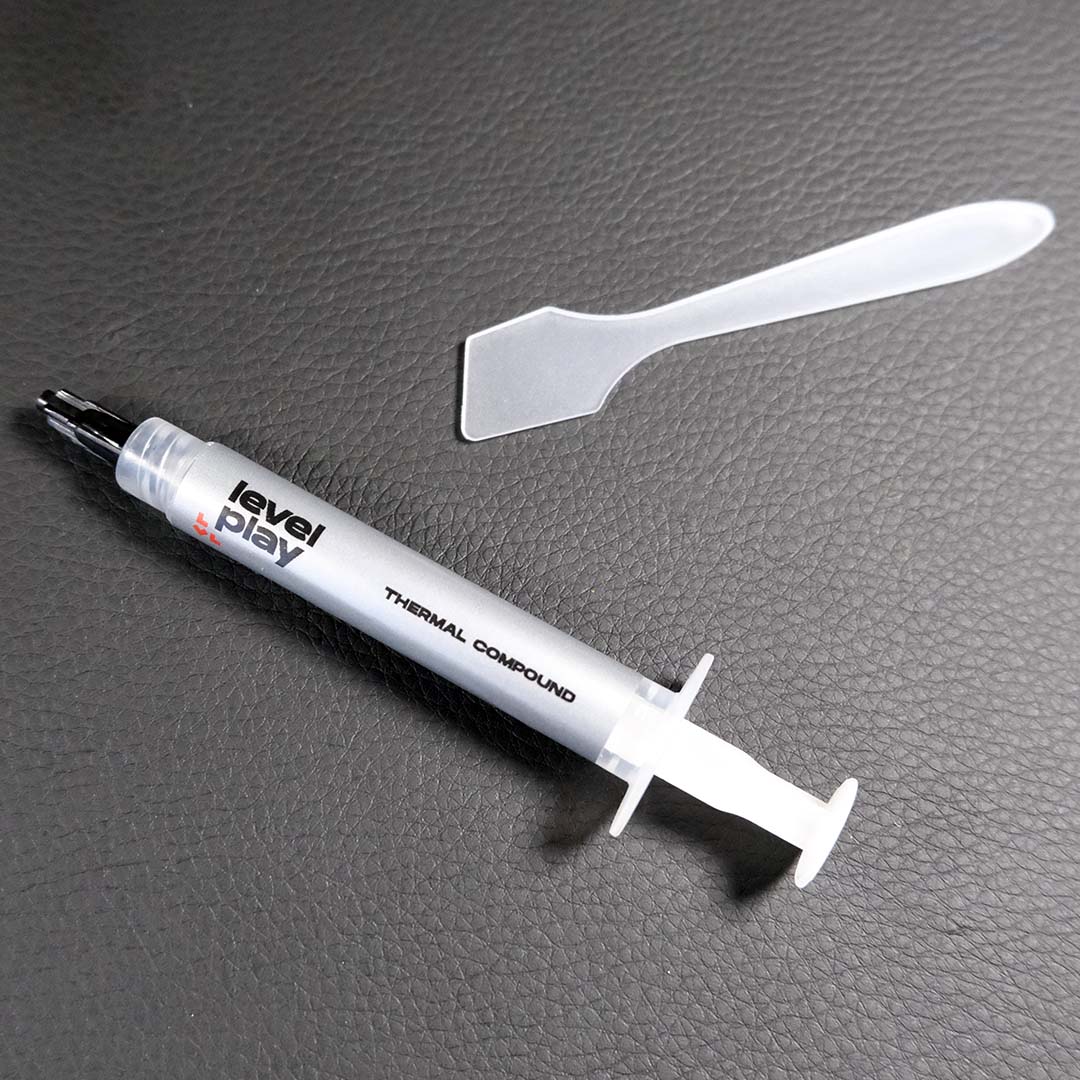 A close-up of the thermal paste and spatula that come with the Levelplay Combat Liquid 360 HUD.