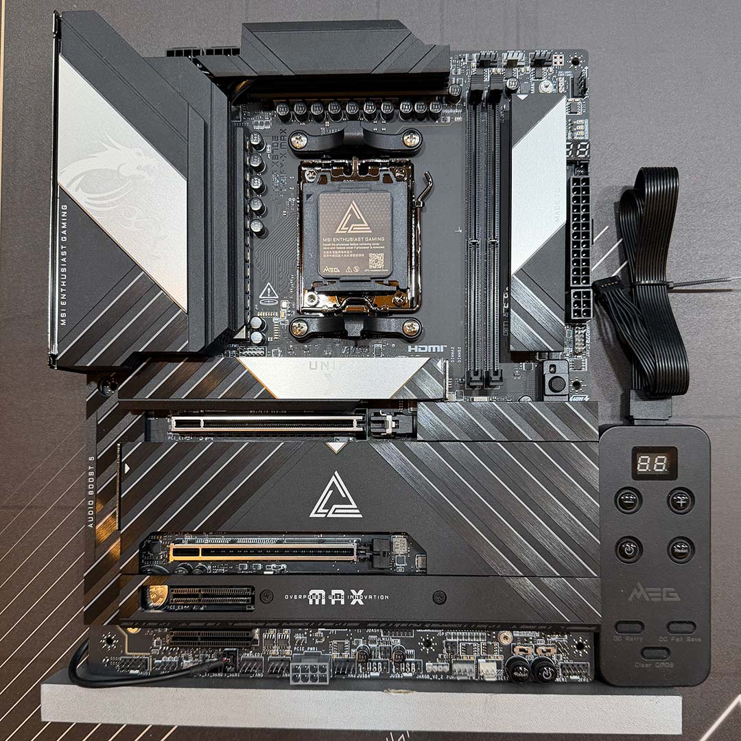 A top-down shot of the MSI MEG X870E Unify-X motherboard, complete with EZ Tuning remote.