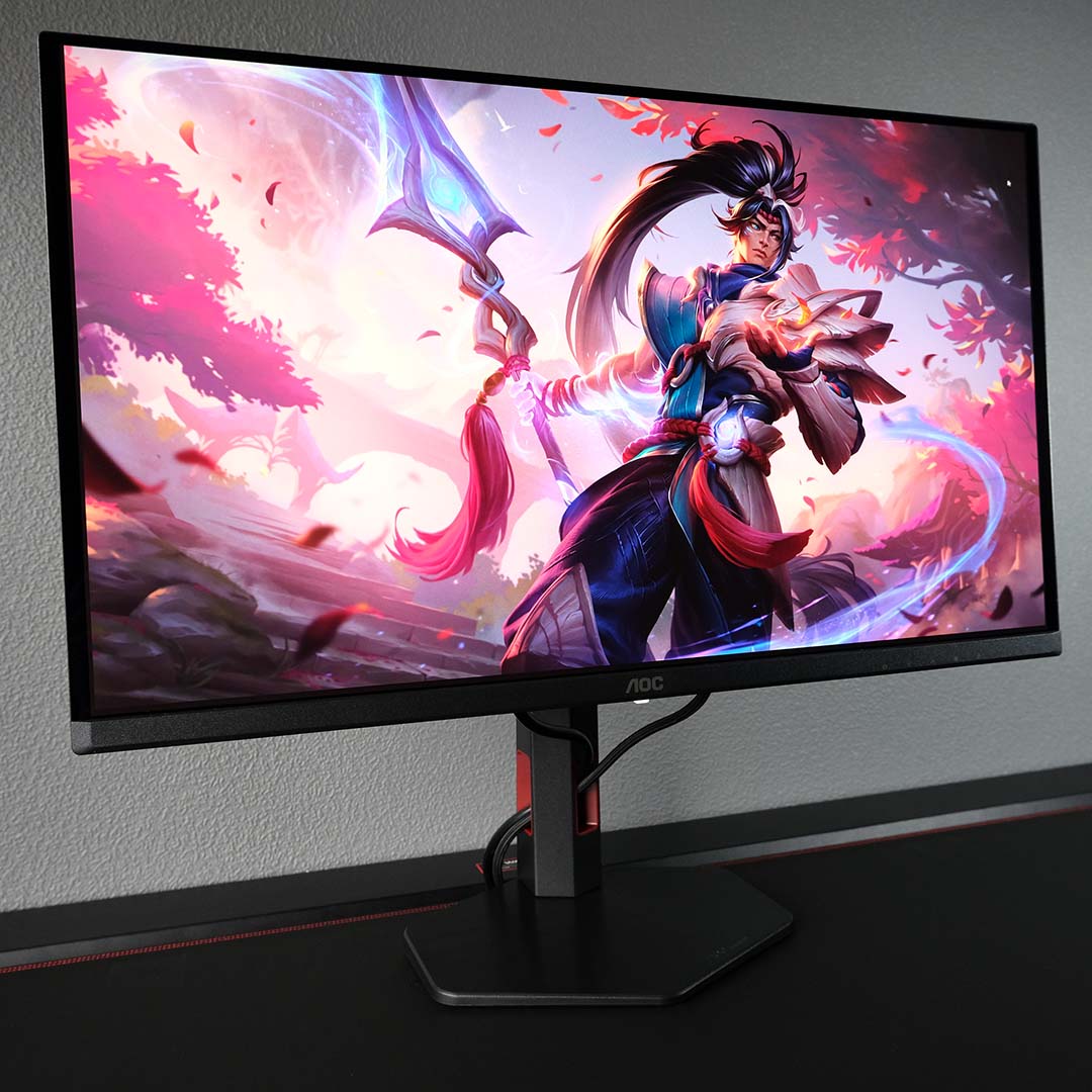 An AOC Q27G4SDR monitor displays character art from League of Legends.