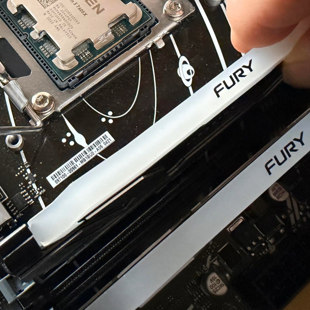 Kingston Fury DDR5 RAM being installed in a motherboard
