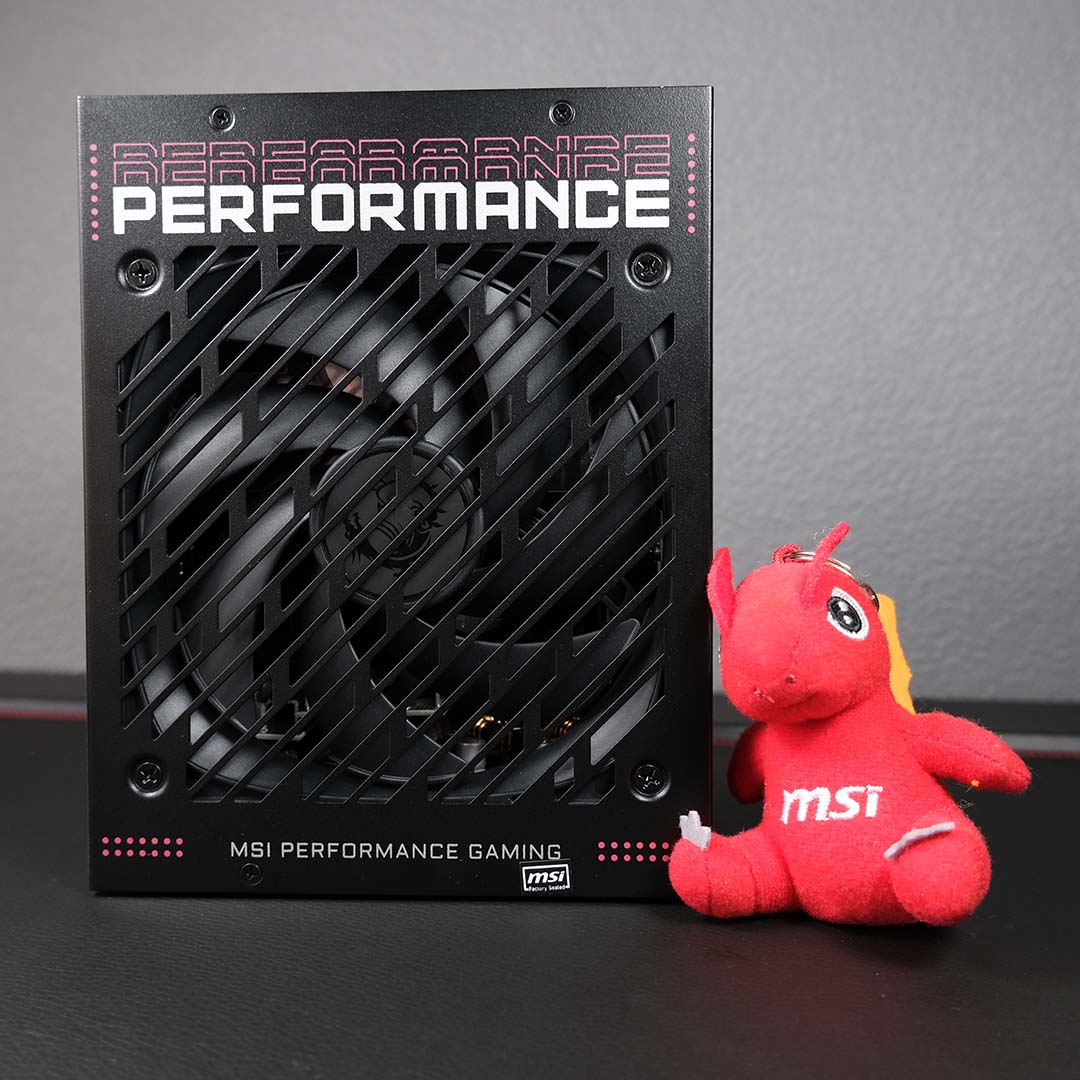 An MPG Ai1600TS PCIE5 power supply (left) and Lucky the Dragon plushie (right).