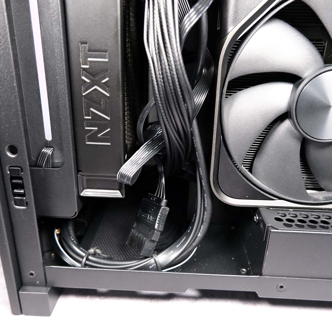 A close-up of loose wires at the bottom of the NZXT H2 Flow.