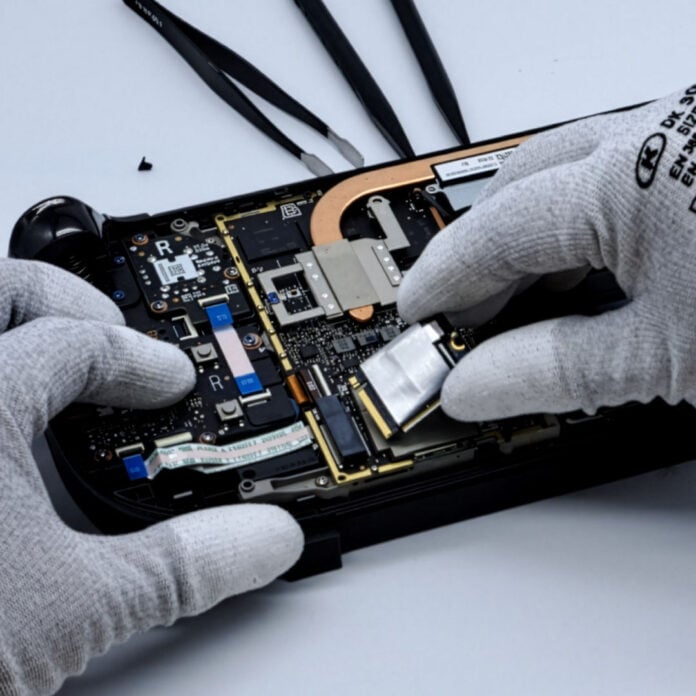 Two hands working on the internals of a Steam Deck.