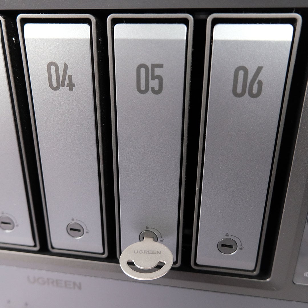 A close-up of some of the Ugreen NASync iDX6011 Pro's drive bays, the unlocking key is inside the centre bay.