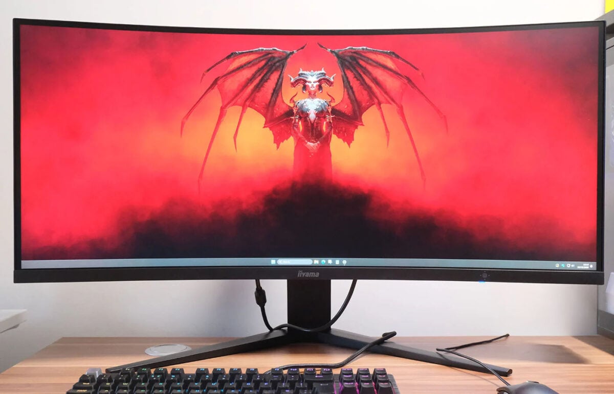 An ultrawide iiyama monitor displaying Diablo 4 key art.