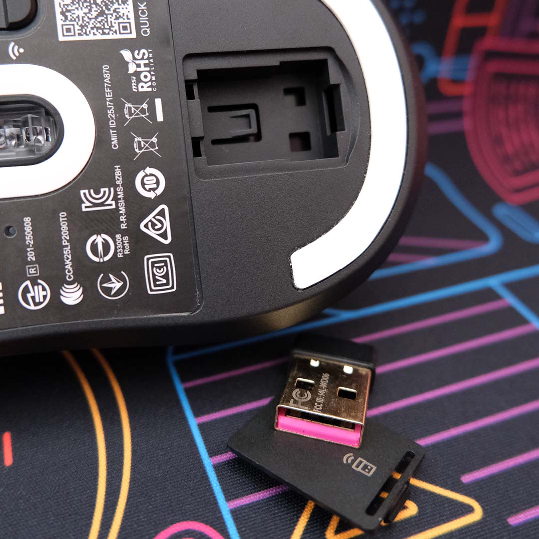 The MSI Vera Wireless 8K's USB compartment, open, with the dongle below it.