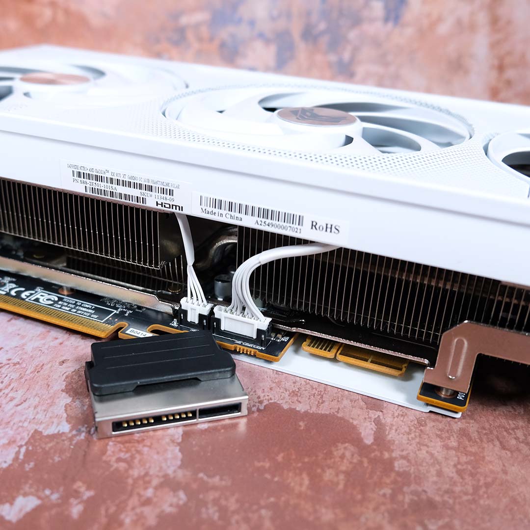 The Nitro+ Radeon RX 9070 XT PhantomLink Edition lies on its back, Phantom Link connector removed.