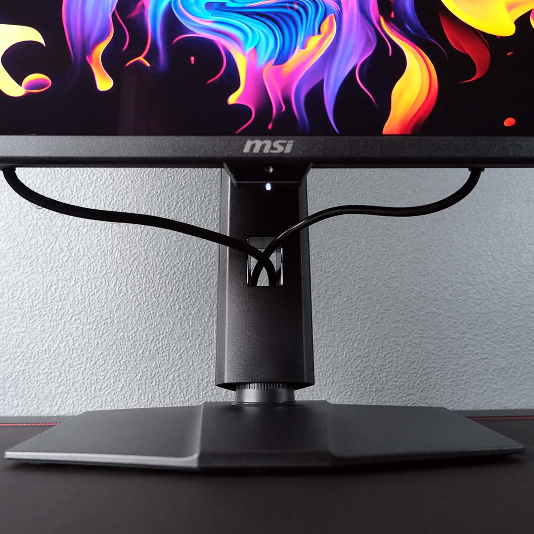 A close-up of cables flowing out of the cut out in the MSI MPG 322UR QD-OLED X24's stand.
