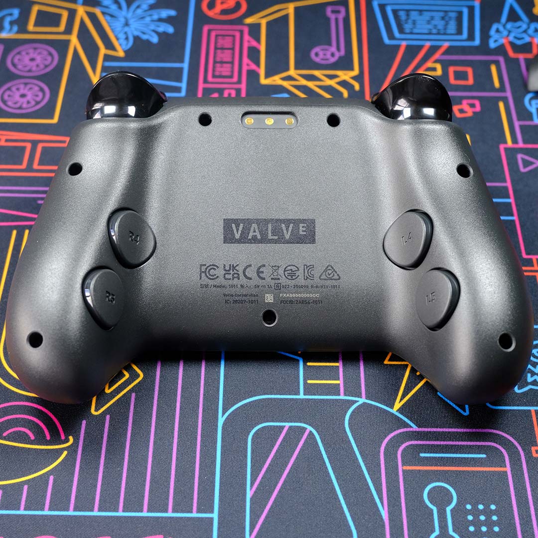 The rear of a Steam Controller, atop a neon backdrop.