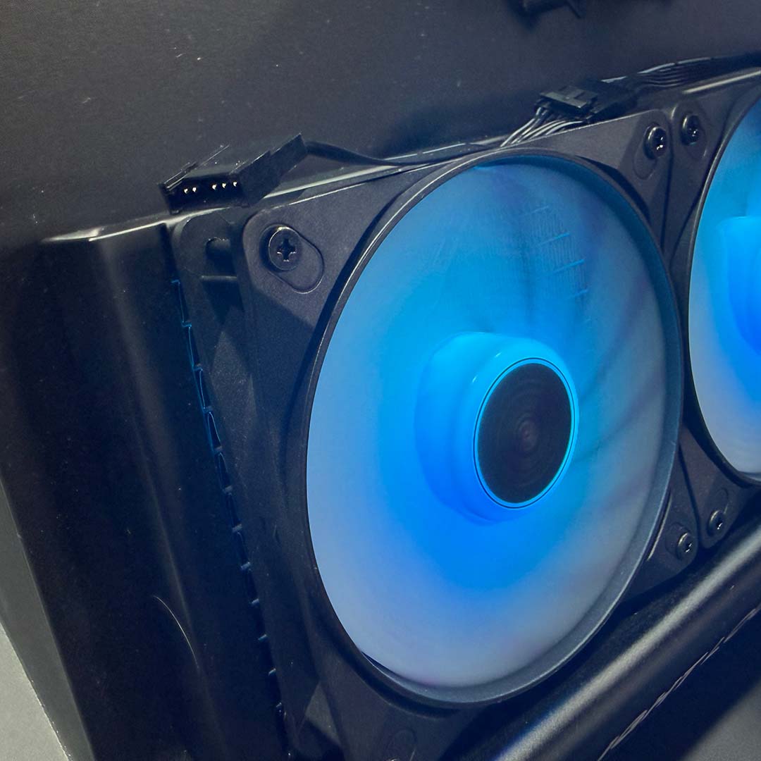 A side-on view of the be quiet! Light Loop IO LCD 240's fans, in black, with blue LCDs.