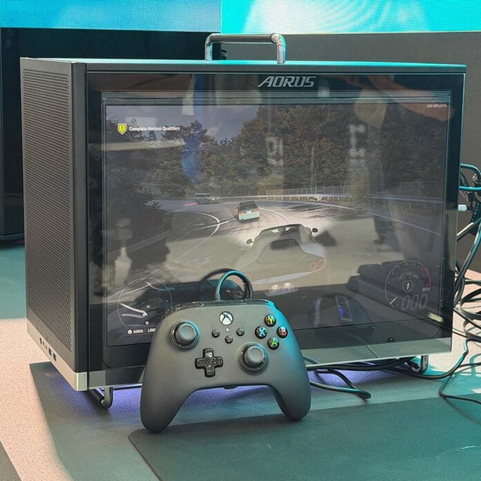The Aorus C510 Glass Infinity, playing Forza Horizon on its display, with an Xbox controller in front of it.