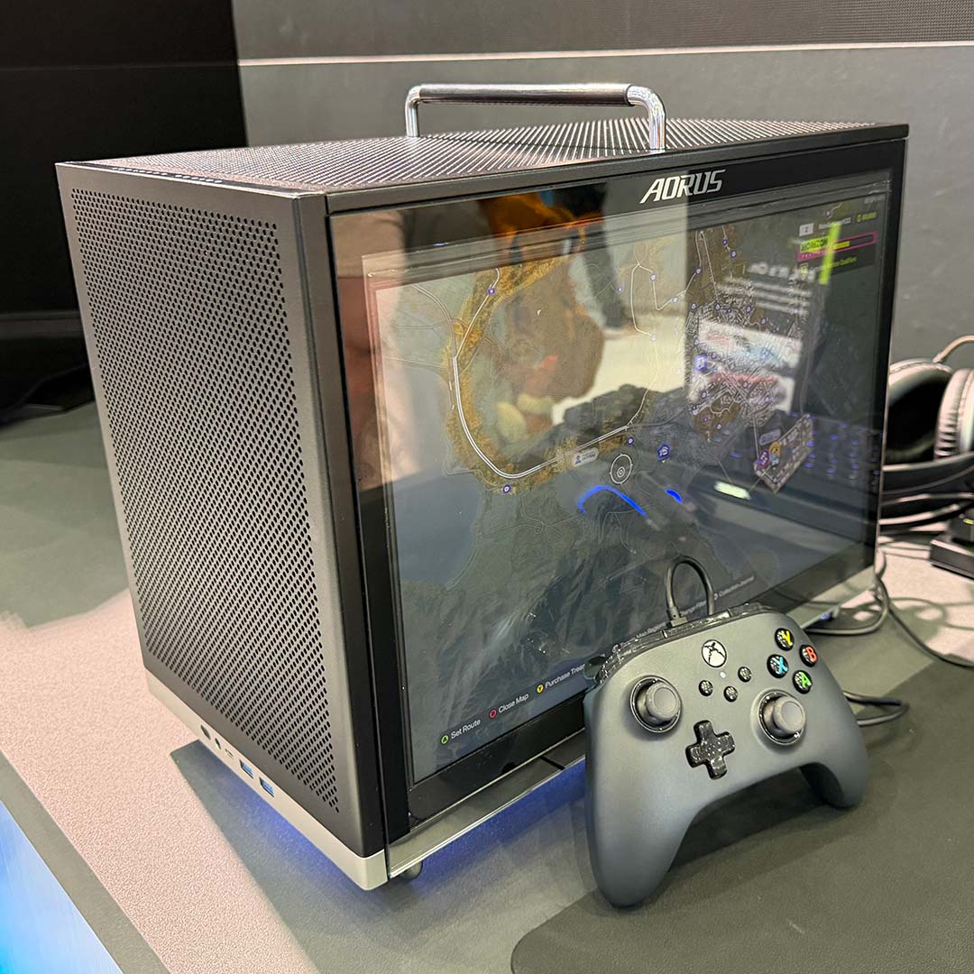The Aorus C510 Glass Infinity, playing Forza Horizon on its display, with an Xbox controller in front of it.