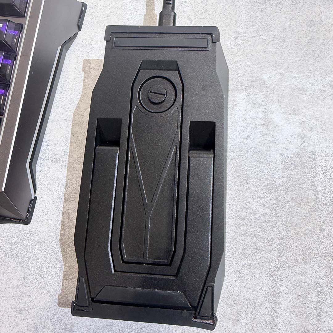 The MSI Strike Nexus, turned upside down, revealing its M.2 slot and hinge.