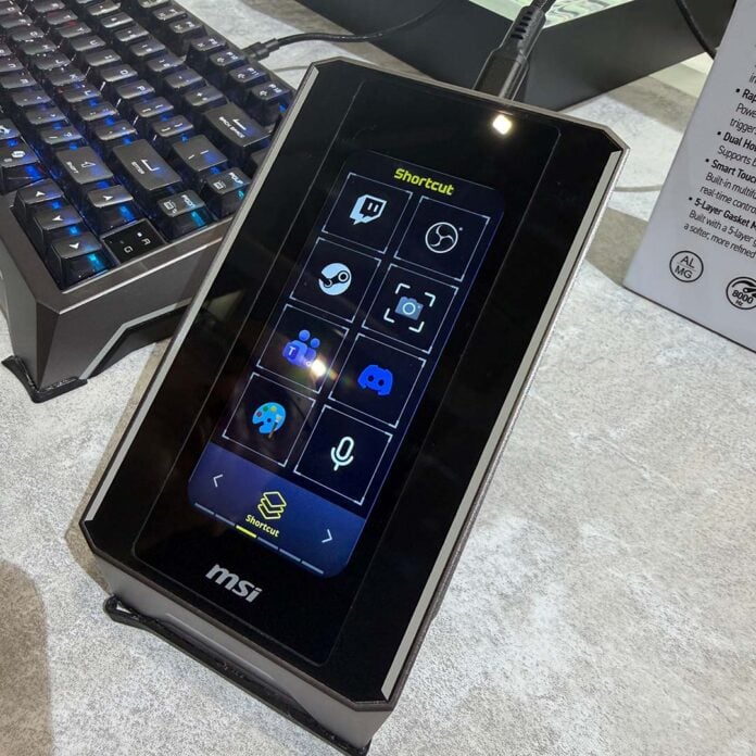 The MSI Strike Nexus, raised up by its hinge, displaying application shortcuts.