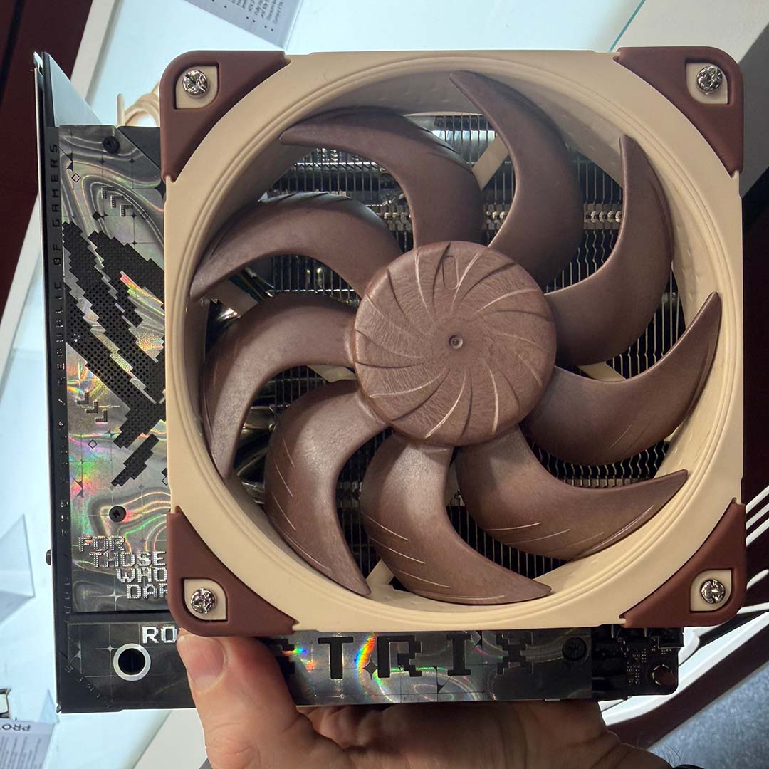 An top-down view of Noctua's prototype low-profile AM5 CPU cooler, with fan, installed on a motherboard.