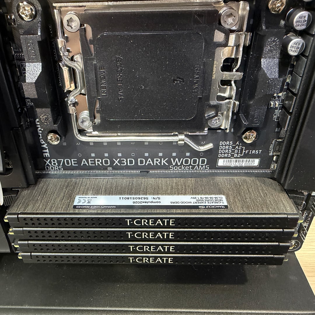 A collection of four TeamGroup T-Create RAM sticks with wood effect finishes, installed in a motherboard.