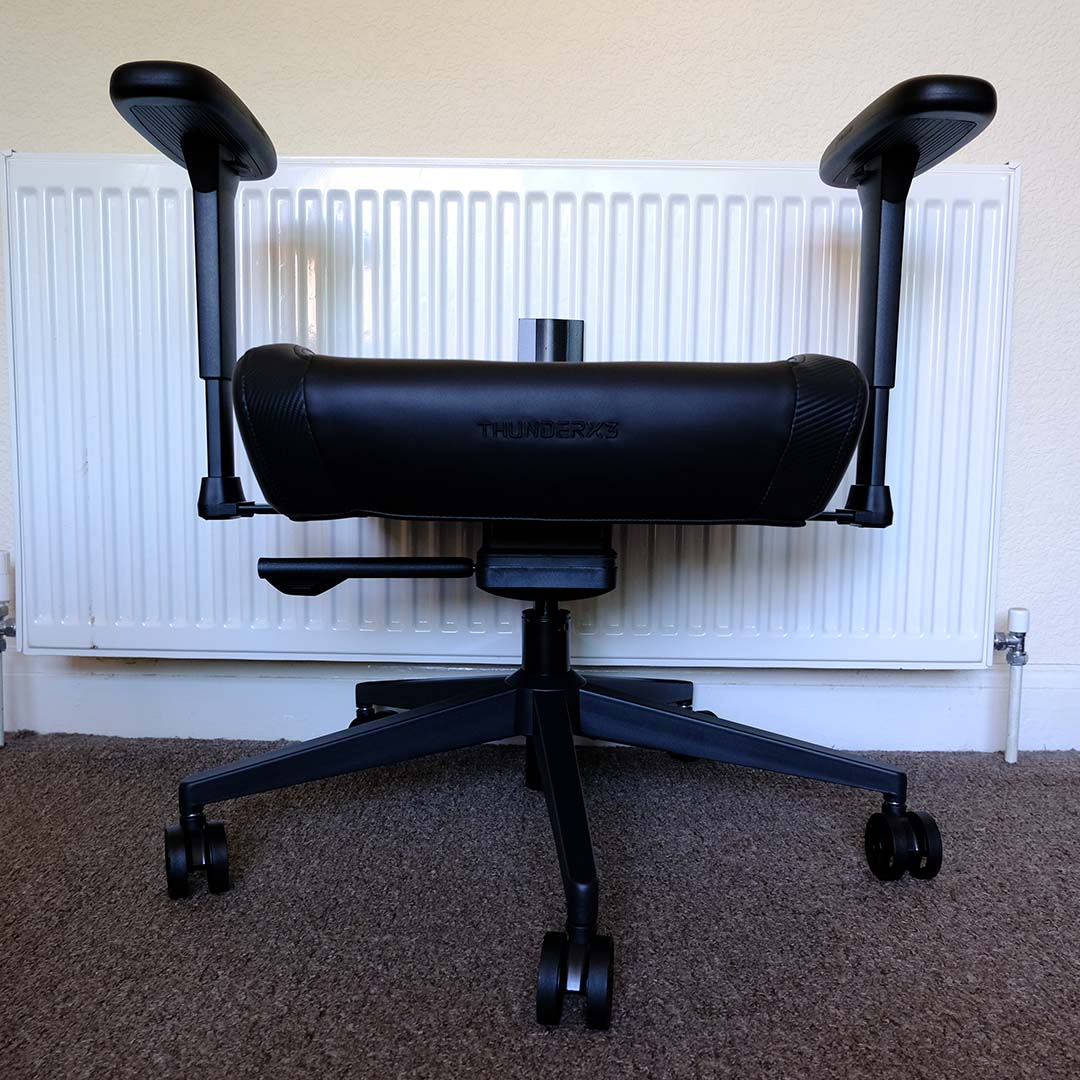 A front view of the ThunderX3 Solo, partially constructed, featuring wheels, arms, and seat cushion.