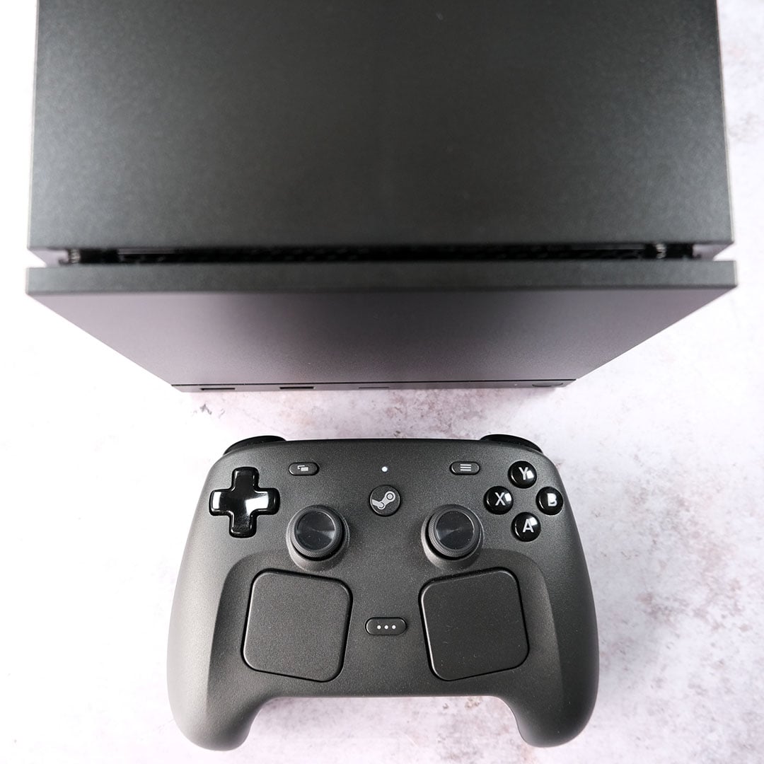 A top-down view of a Steam Controller, in front of a Steam Machine.