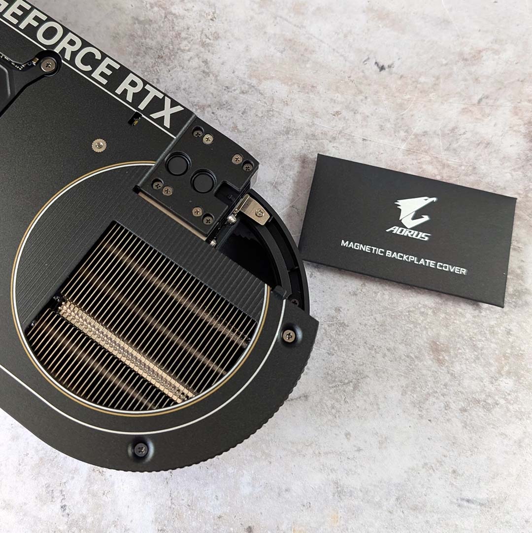 A Gigabyte Aorus GeForce RTX 5070 Infinity (left) next to packaging for the magnetic backplate cover (right).