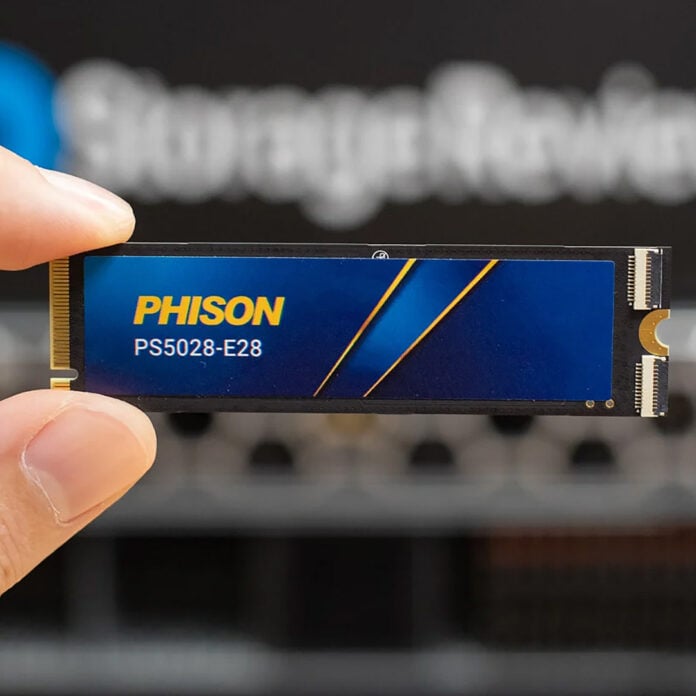 A Phison SSD, held between two fingers.