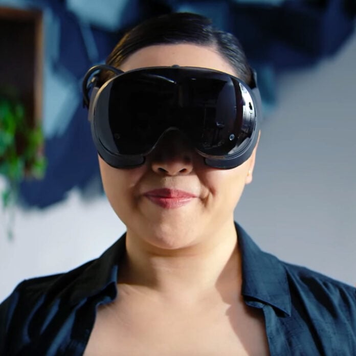 A female-presenting person, wearing a Steam Frame.