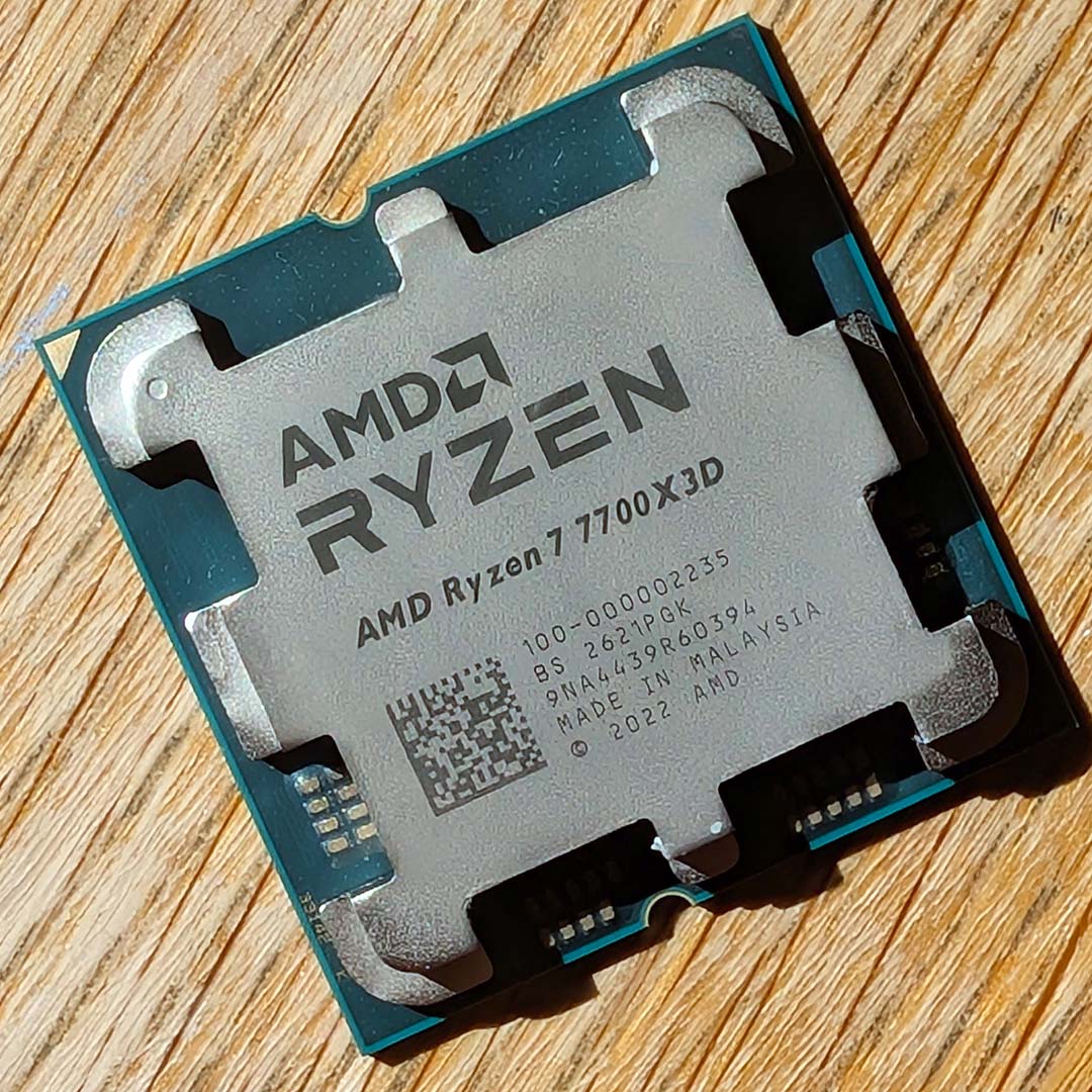An AMD Ryzen 7 7700X3D atop a wooden backdrop.