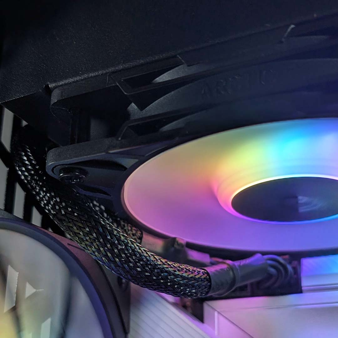 A close-up of CPU power cables routing along the side of a cooler inside the Hyte Y50 RGB.