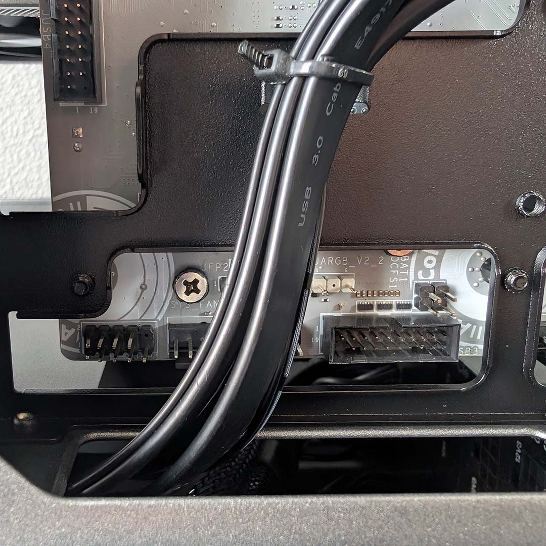 A close-up of cables blocking motherboard headers in the MSI MPG Vixta 300R PZ.