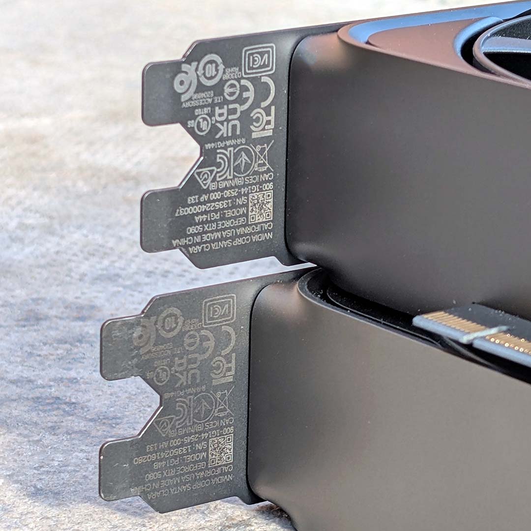Two Founders Edition graphics cards stacked on top of another, with differing amounts of wear on their serial number prints.