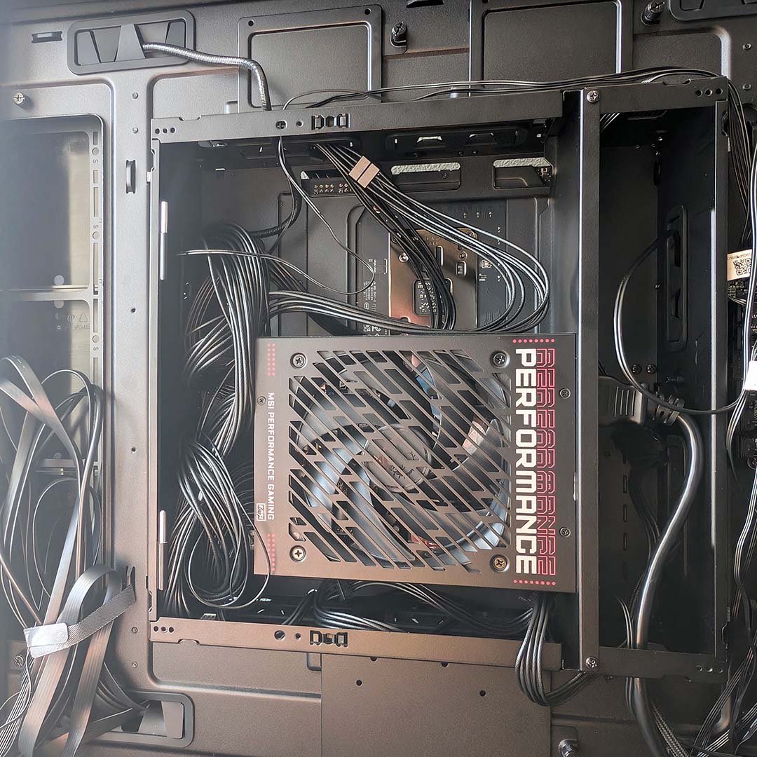 The PSU shroud in the MSI MEG Maestro 900R, filled with cables.