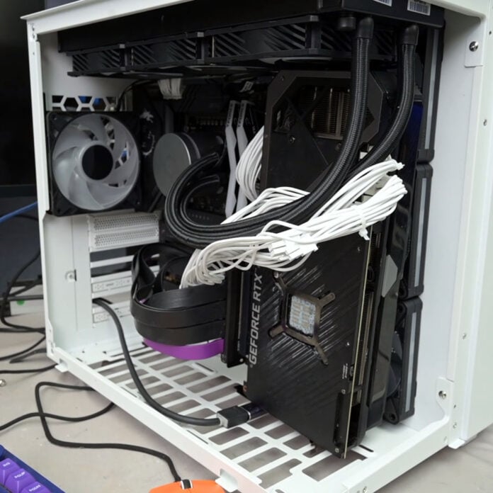 A graphics card sits in front of an intake fan inside a PC case.